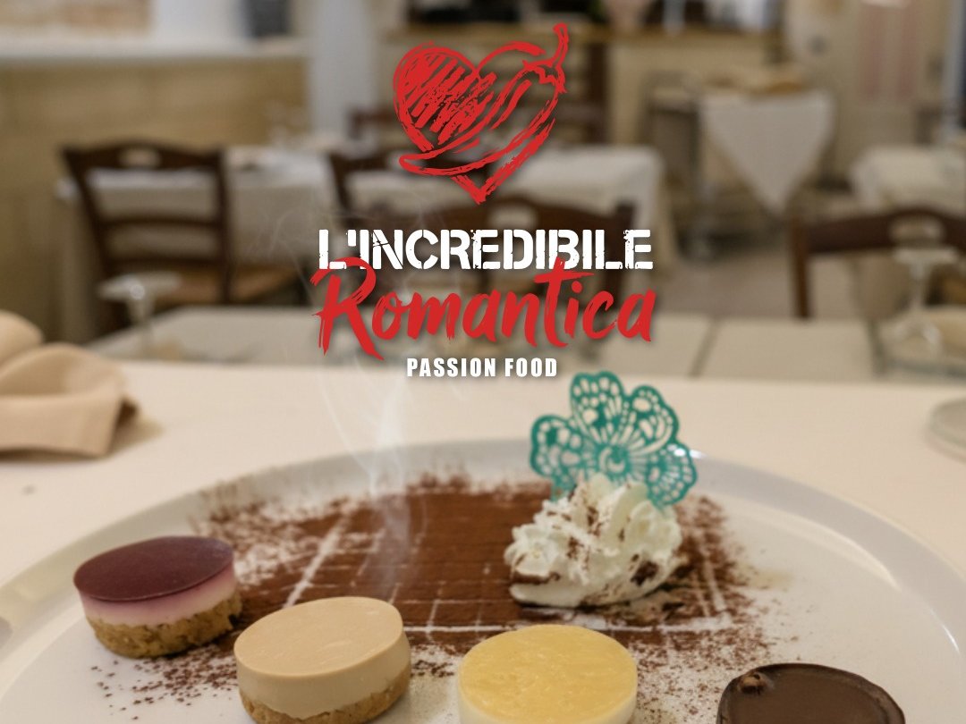 Mini cheesecake assortite su cacao con panna e decoro turchese, logo L'Incredibile Romantica Passion Food, sala sfocata